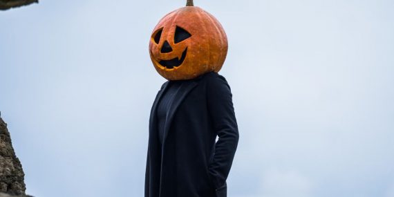 A person in a Halloween pumpkin head costume outdoors in Guasca, Colombia.